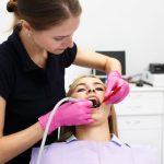 pregnant woman receiving a dental checkup from a dentist during a routine oral health examination in a dental clinic